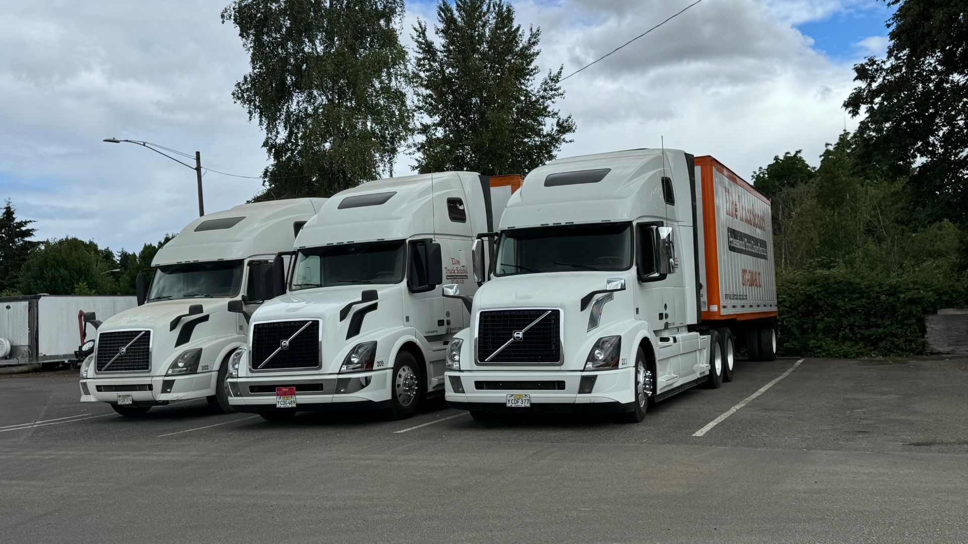 Image of three Elite Truck School semi trucks from the front