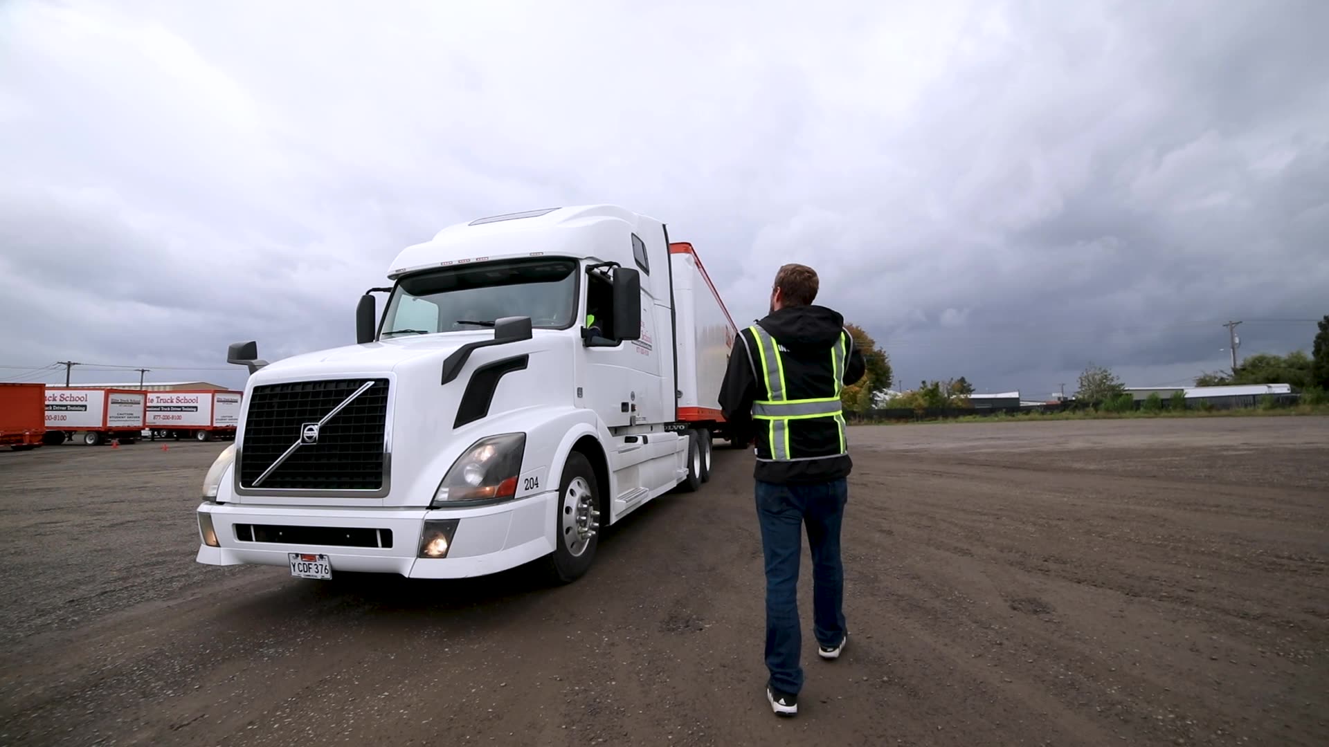 Elite semi truck parked, trucker walking toward cab