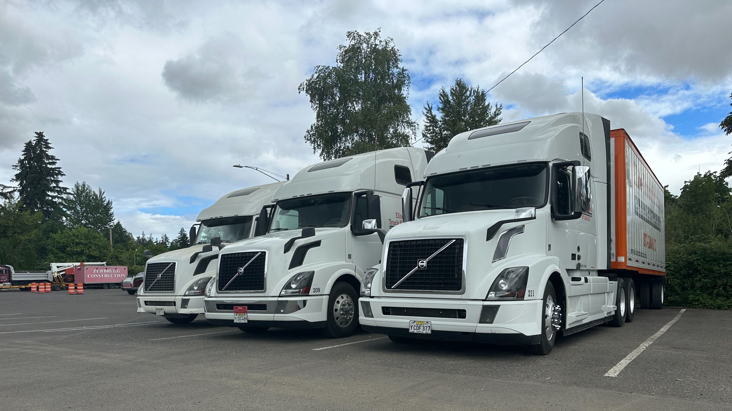 Three semi trucks parked in a row, shown diagonally