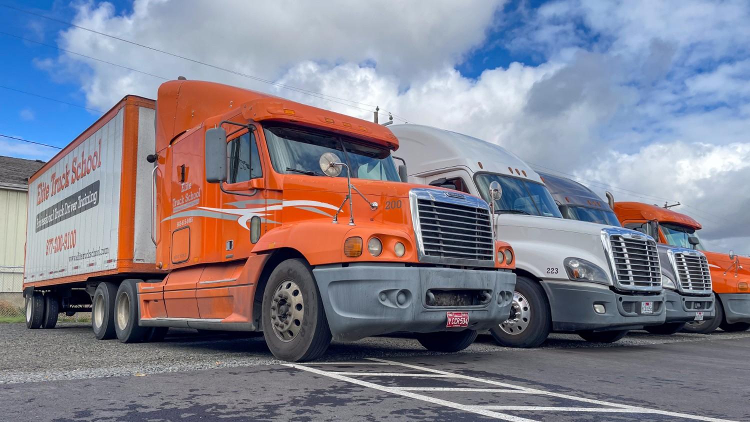 Three Elite semi trucks parked in a line