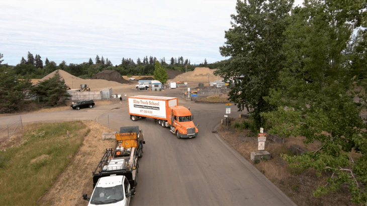 Drone shot of Elite semi truck driving on a dirt road out of construction area
