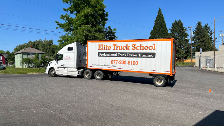 Side view of Elite semi truck parked in paved training lot