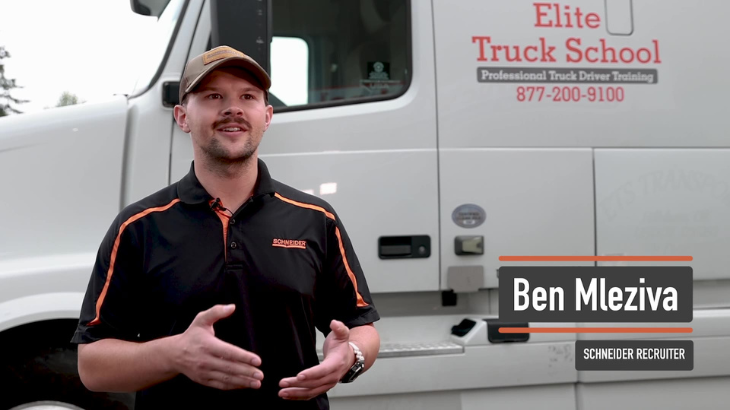 Schneider recruiter smiling and standing in front of Elite semi truck