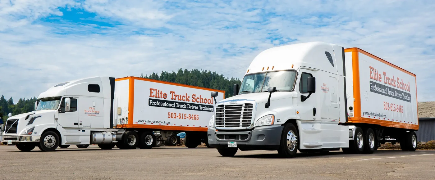 Two Elite semi trucks parked next to each other in training yard
