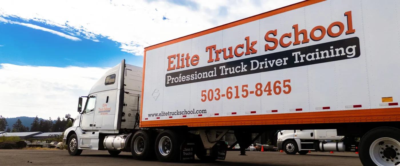 White Elite Truck School semi truck parked outdoors under a blue sky at a CDL training lot.